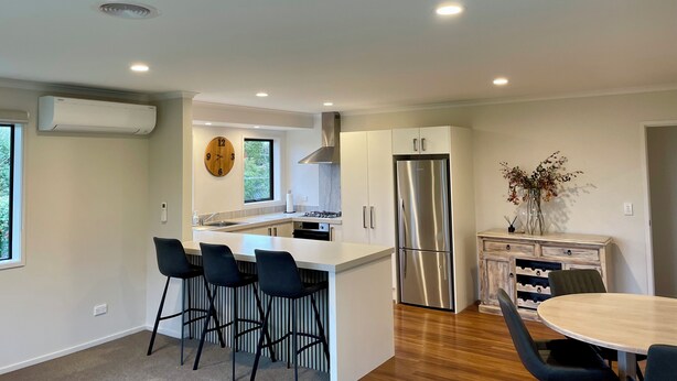 A modern kitchen with a central island, stainless steel appliances, and bar stools. - Stunning views in quiet location, luggate. 10 mins out of Wanaka. (Luggate)