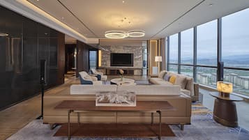 Una sala de estar moderna con un televisor grande, asientos cómodos y vistas a la ciudad.