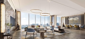 Una sala de estar moderna con vista a la ciudad, ventanas amplias y muebles contemporáneos.