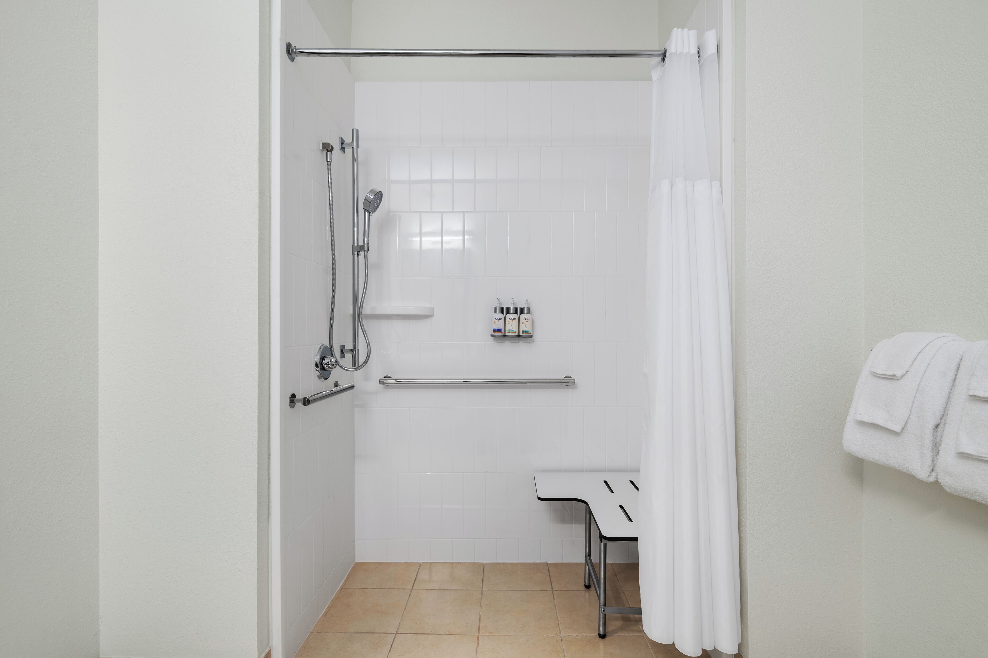 A bathroom with a shower, a towel rack, and a toilet.