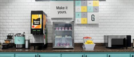 Eine Küchenzeile mit Kaffeemaschine, Kühlschrank und Mikrowelle.