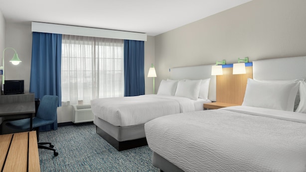 A hotel room with two beds, a desk, a chair, a desk lamp, and a window with curtains. - Garner Hotel Madison Huntsville Airport by IHG (Madison)