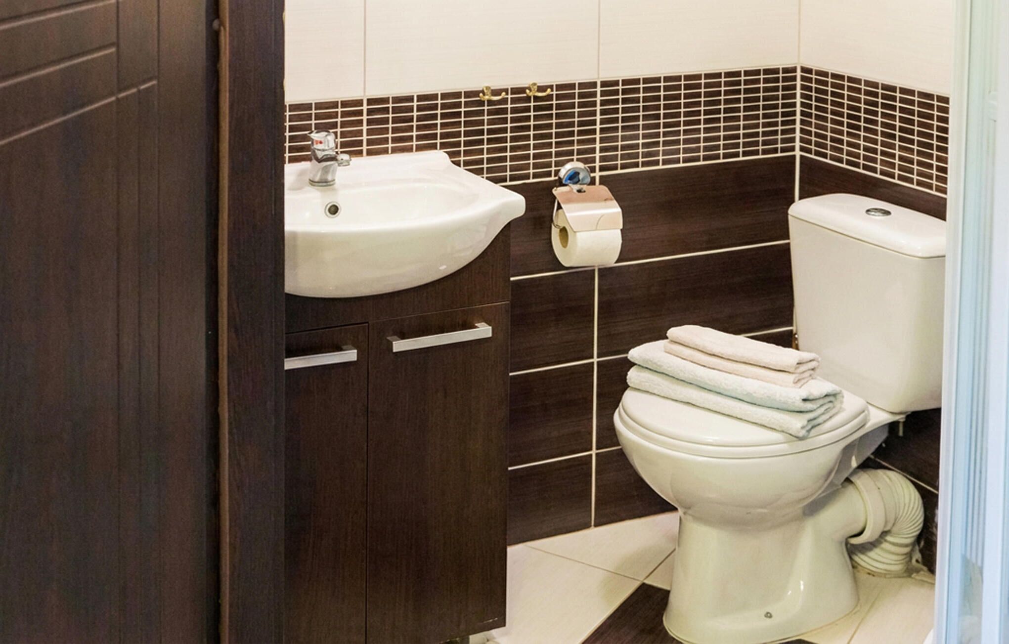 Une salle de bain avec un lavabo, des toilettes et une pile de serviettes.