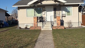 A single-story house with a front porch, a welcome sign, and a number 2407 on the door.