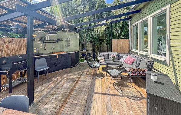 A covered patio with a grill, seating, and a view of the house. - 5 bedroom beautiful home in Dalby (Dalby)