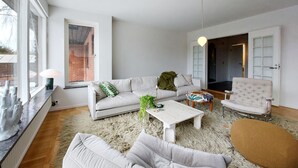 Un salon moderne comprenant un canapé, un fauteuil, une table basse et un tapis.