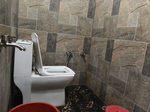 A bathroom with a toilet, a shower, and a sink. - Balaji Guest House (Varanasi)