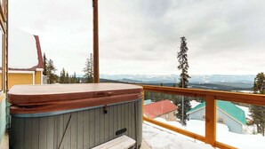 A wooden deck with a hot tub and a view of snow-covered mountains. - Okanagan - Arolla Chalet D (Big White Mountain)