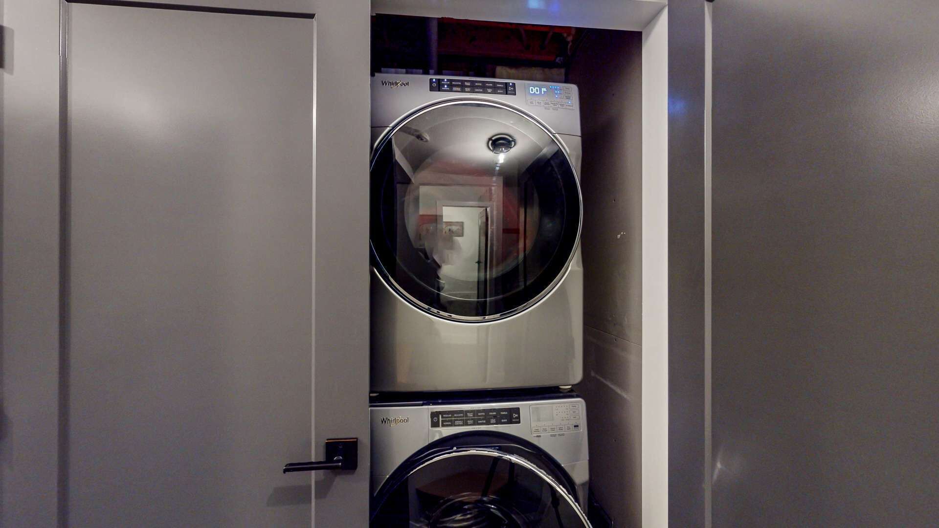 Un lavadero moderno y compacto con dos lavadoras Whirlpool apiladas.