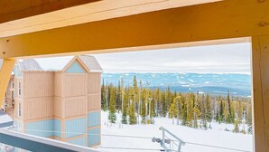 A wooden cabin with a view of a snowy mountain landscape and a ski lift. - Okanagan - Hilltop Hideaway Condo - Legacy 401A (Beaverdell)