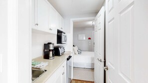 A compact kitchen with white cabinets, a coffee maker, a toaster, and a microwave. - Okanagan - Hilltop Hideaway Suite - Legacy 401B (Beaverdell)