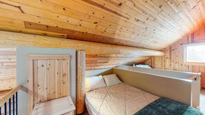 A wooden attic bedroom with a bunk bed, a window, and a door. - Okanagan - Lac Le Jeune at Cabin 3 (Kamloops)