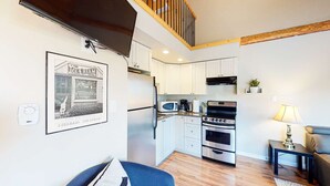 A compact kitchen with white cabinets, a microwave, a coffee maker, and a stove. - Okanagan - Lac Le Jeune at Cabin 3 (Kamloops)