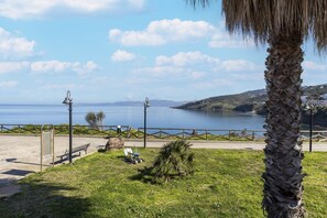 A coastal park with a bench, a lamp post, and a palm tree. - Con vista mare, terrazza, aria condizionata (Castelsardo)