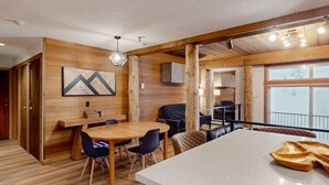 Un interior de madera con comedor, un ventanal y vistas al exterior.