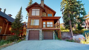 A two-story log cabin with a stone foundation, a front porch, and a garage. - Okanagan - Northern Star (Kootenay Boundary E)