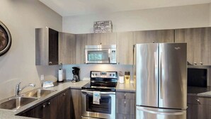 A modern kitchen with stainless steel appliances, a built-in oven, and a microwave. - Okanagan - Sunshine Beach (Christina Lake)