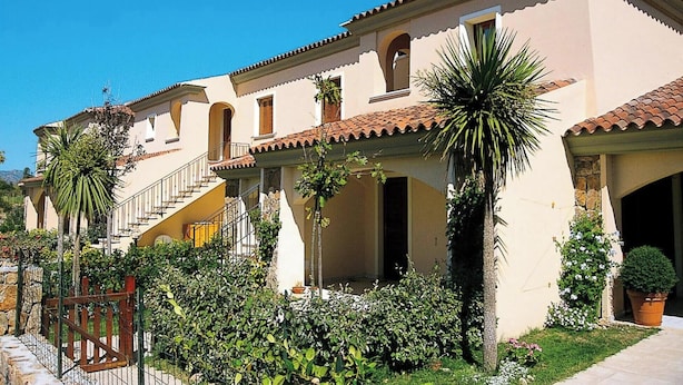 Ein Gebäude im mediterranen Stil mit einem Ziegeldach, Bogenfenstern und einer zentralen Treppe.