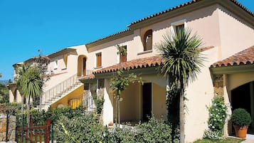 Un bâtiment de style méditerranéen, doté d’un toit en tuiles, de fenêtres en arc de cercle et d’un escalier central.