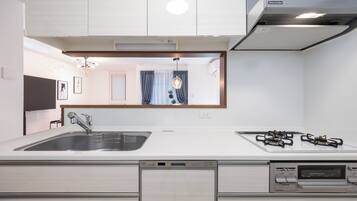 A modern kitchen with a stainless steel sink, a dishwasher, and a gas stove.