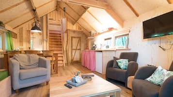 A cozy wooden cabin interior with a dining area, kitchen, and seating space.