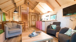 A cozy wooden cabin interior with a dining area, kitchen, and seating space. - Boshuis Dorus met sauna | park d`n Mastendol (Rijen)