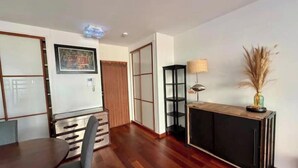 A modern living room with a wooden floor, a dining table with chairs, a black console table with a lamp, and a sliding door closet. - NEW! "Le Débarcadère" 4P near Palais Congrès (Paris)