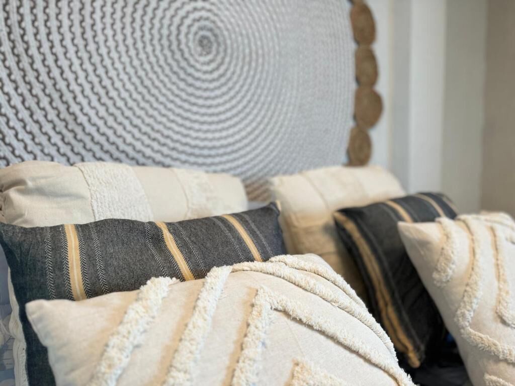 A close-up of a bed with multiple pillows and a textured blanket.