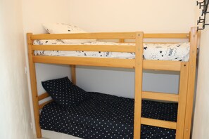 A bunk bed with a white and black patterned mattress, a wooden frame, and a pillow with a star pattern. - Studio with harbour view, close to the beach - Carnon ideal for short stays (Mauguio)