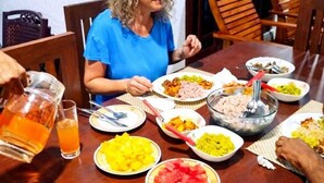 A dining table with various dishes and a pitcher of orange liquid. - Wilpattu Gagana Guest  (Pahala Maragahawewa)