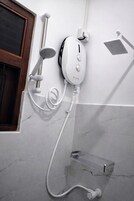 Chuveiro, toalhas de banho, papel higiênico