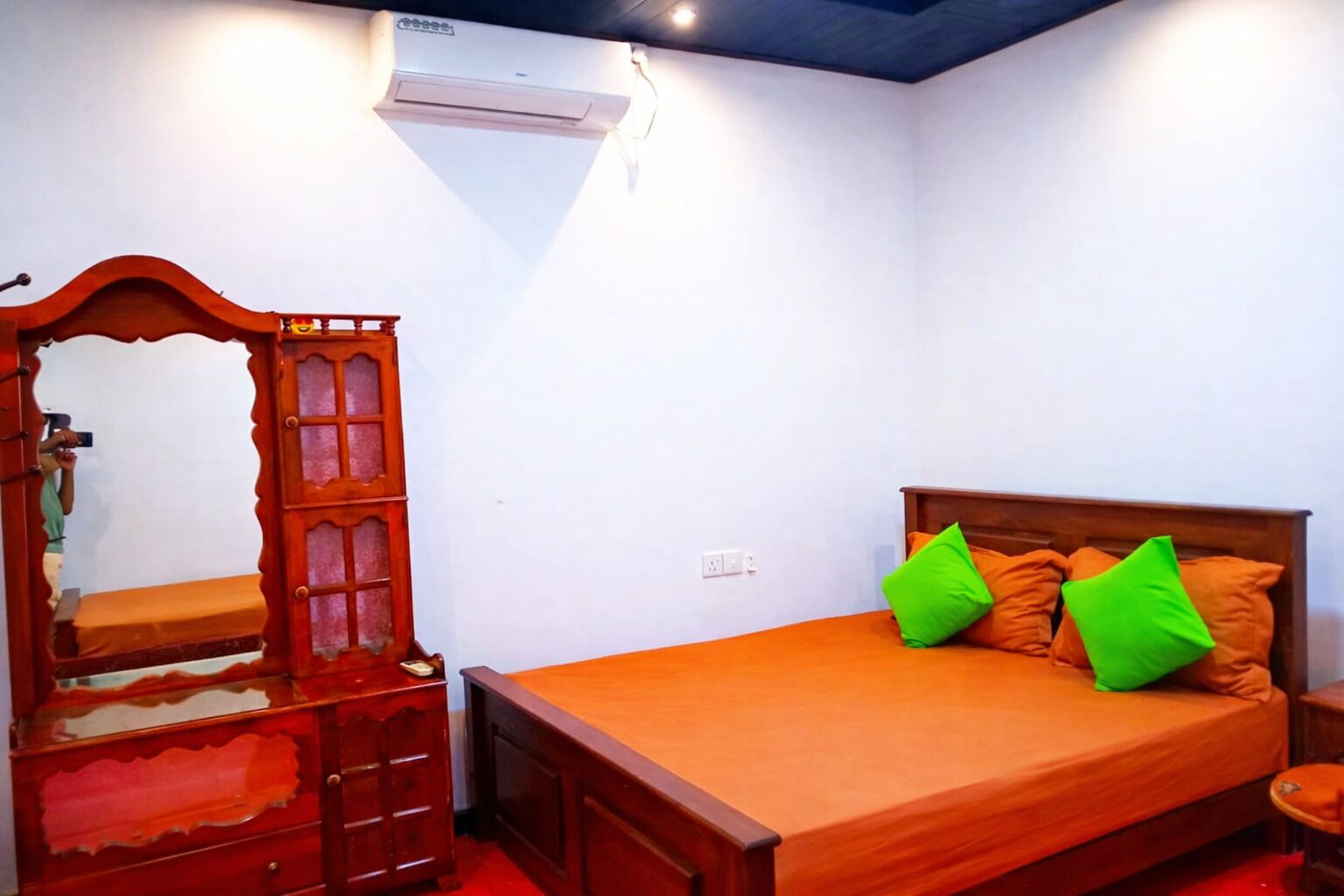 A bedroom with a wooden bed, a mirror, and a dresser.