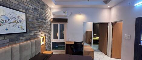 Un dormitorio moderno con pared de ladrillo, una cama, un escritorio y vestidor.