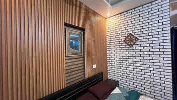 Una stanza moderna con parete in legno a listelli, un quadro incorniciato, una parete con motivo a mattoni e una panca.