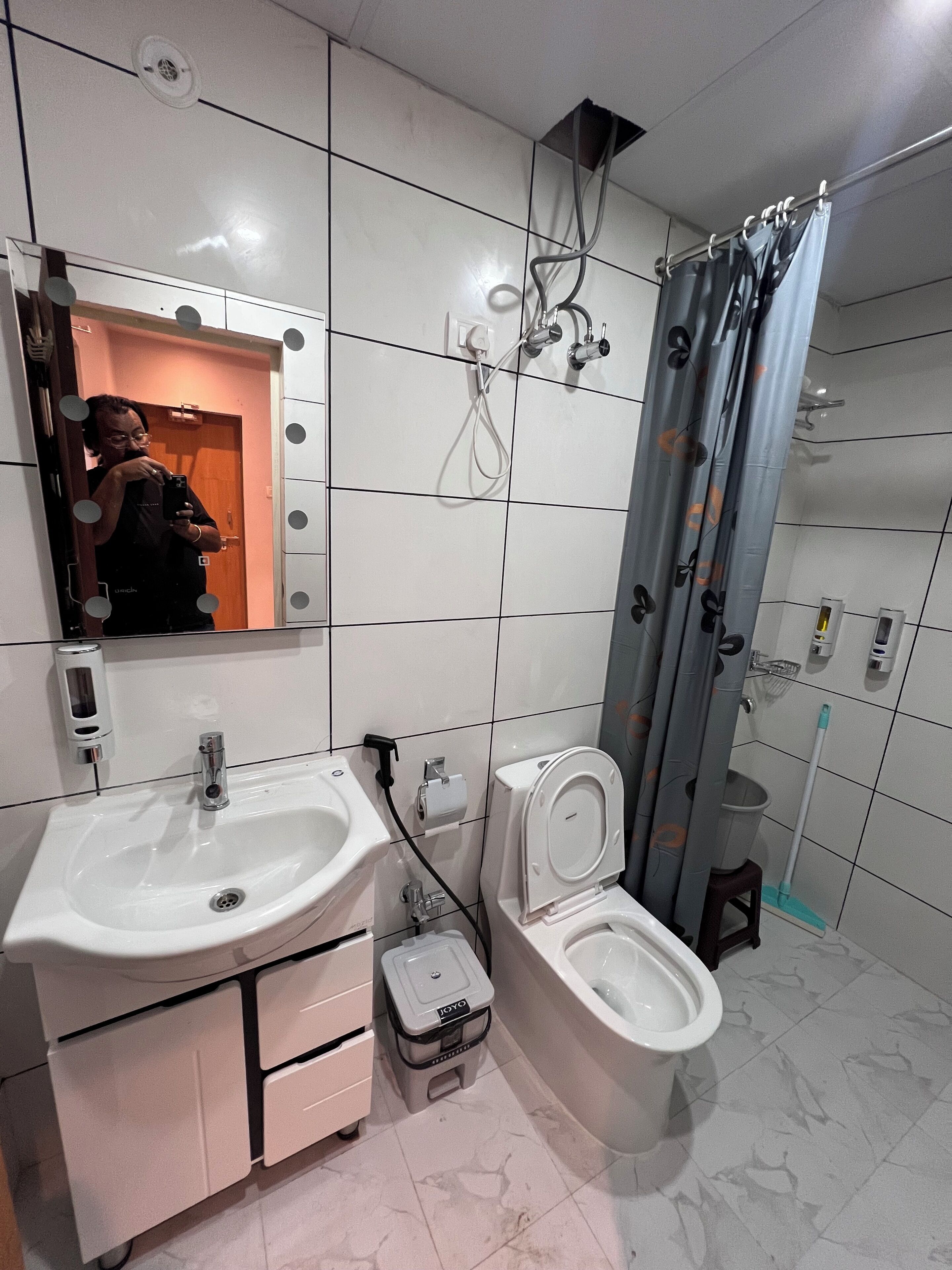Une salle de bain moderne équipée d’un meuble-lavabo, d’un lavabo, de toilettes et d’une douche.
