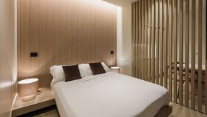 A modern bedroom with a bed, bedside lamps, and a wooden slat partition. - Evangelisti Palace (Bellaria-Igea Marina)