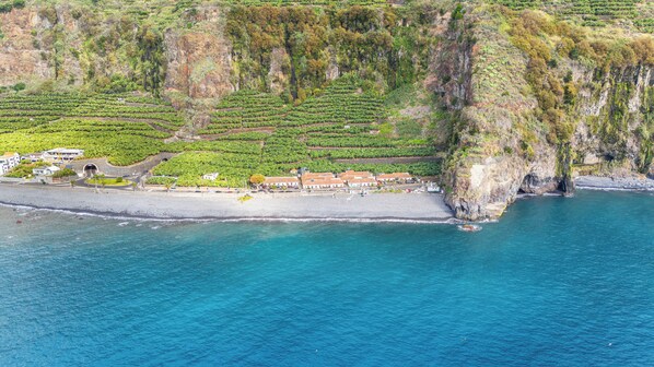 Une propriété située sur la côte, dotée de vignobles en terrasses, d’une plage et d’une falaise.