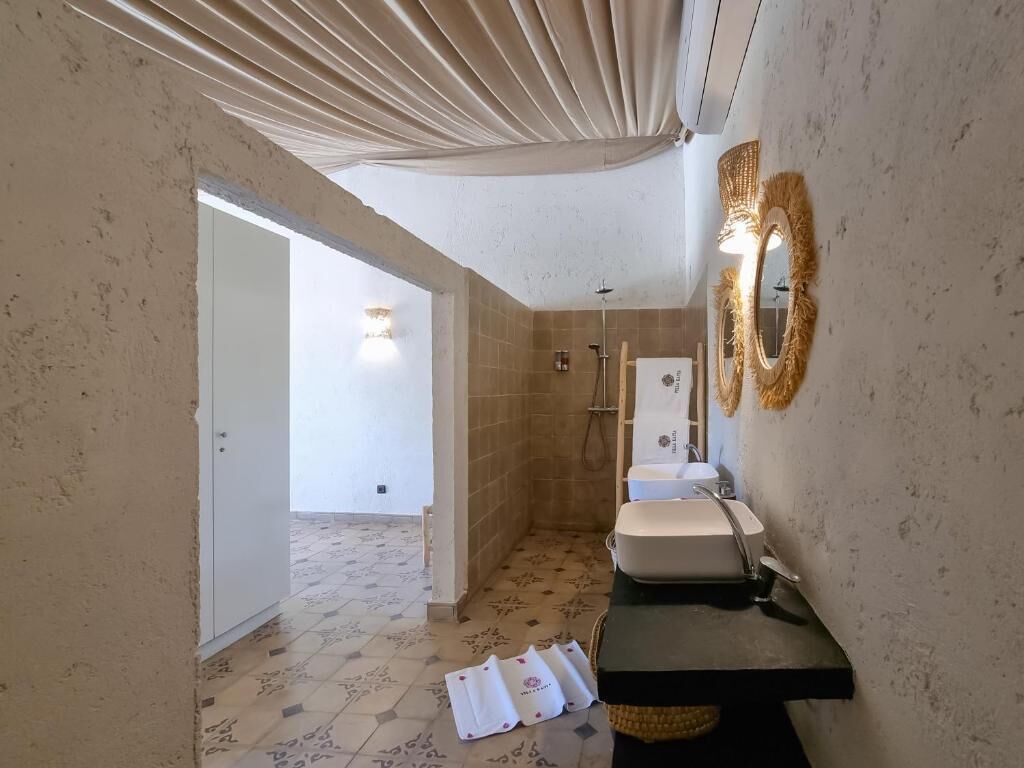 A bathroom with a shower, a sink, and a mirror.