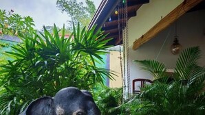 An elephant standing on a wooden deck surrounded by potted plants. - Lake Reach Hotel (Kandy)