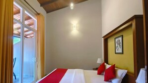 A hotel room with a bed, a nightstand, a lamp, and a window with curtains. - Lake Reach Hotel (Kandy)