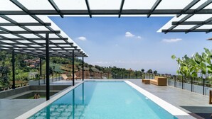A rooftop swimming pool with a pergola, lounge chairs, and a view of the surrounding landscape. - Diamond Hill 10 Br Heated Pool (Bandung)