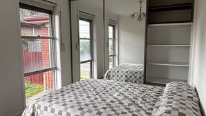 Une chambre à coucher avec un grand lit, une armoire et un miroir.