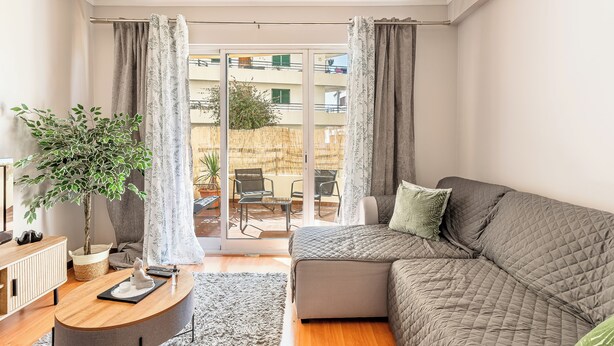 Ein modernes Wohnzimmer mit einer Couch, einem Couchtisch und einem Blumentopf.