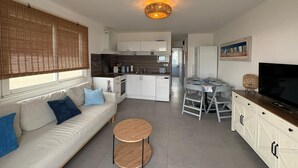 A modern apartment with a living room, dining area, kitchen, and a balcony. - Dream house ground floor on the beach: prime location at the Mediterranean Sea (Palavas-les-Flots)