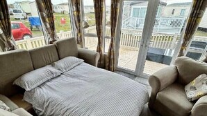 Ein Zimmer mit einem Bett, zwei Sofas und einem kleinen Tisch.