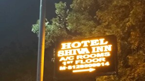 A neon sign for Hotel Shiva Inn, indicating 1st floor rooms and a contact number. - hotel shiva inn (Ahmedabad)
