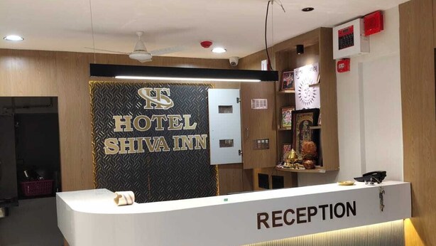 A reception desk with a sign reading "HOTEL SHINAI INN" and a "RECEPTION" label. - hotel shiva inn (Ahmedabad)