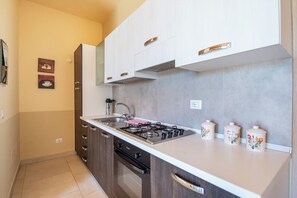Eine moderne Küche mit Gasherd, Edelstahlspüle und Holzschränken.