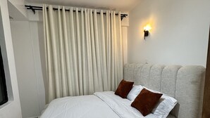 Ein modernes Schlafzimmer mit einem großen Bett, einer hängenden Leuchte und einer Wandlampe.