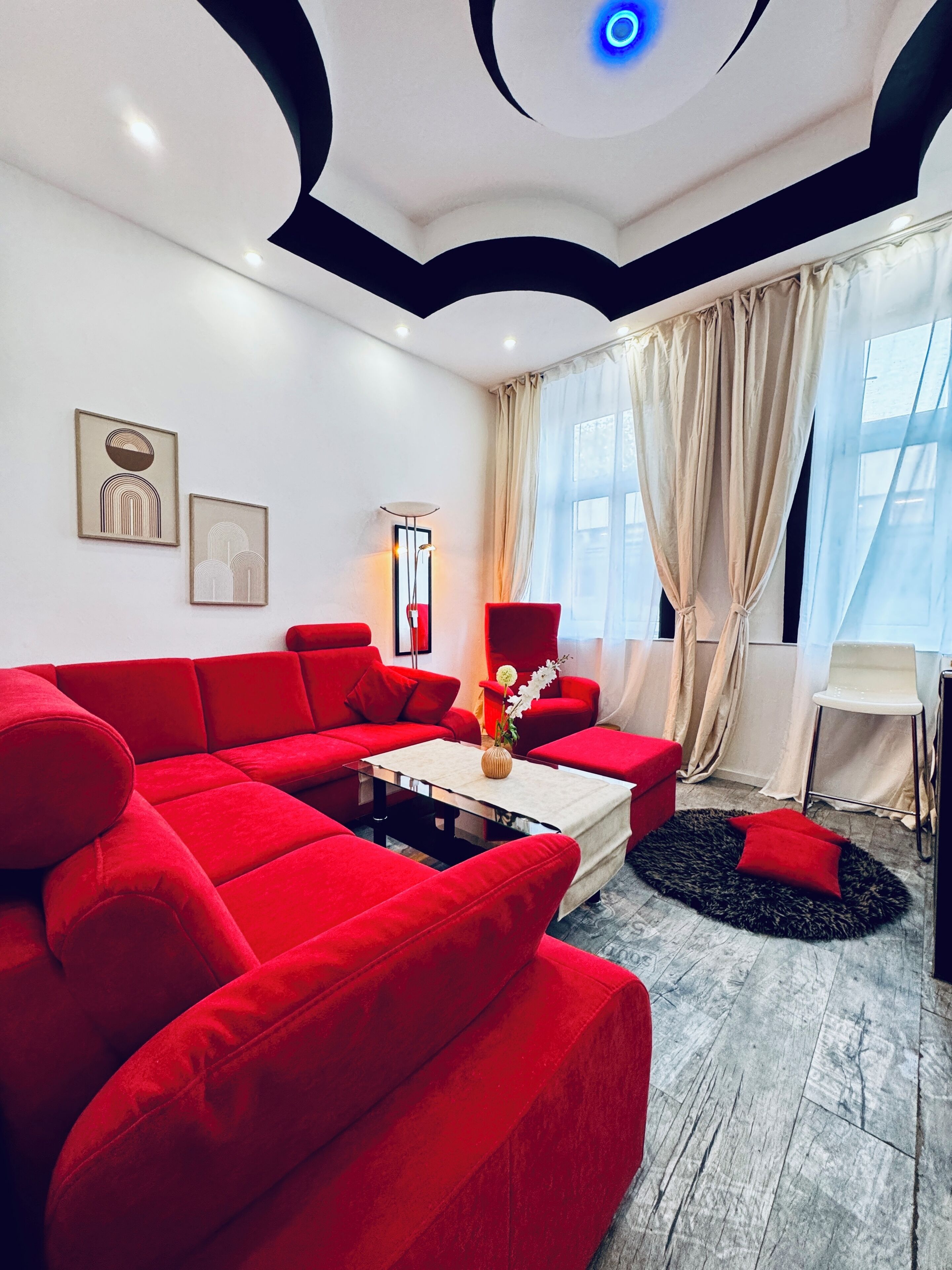 A modern living room with a red sectional sofa, a coffee table, and artwork on the walls.